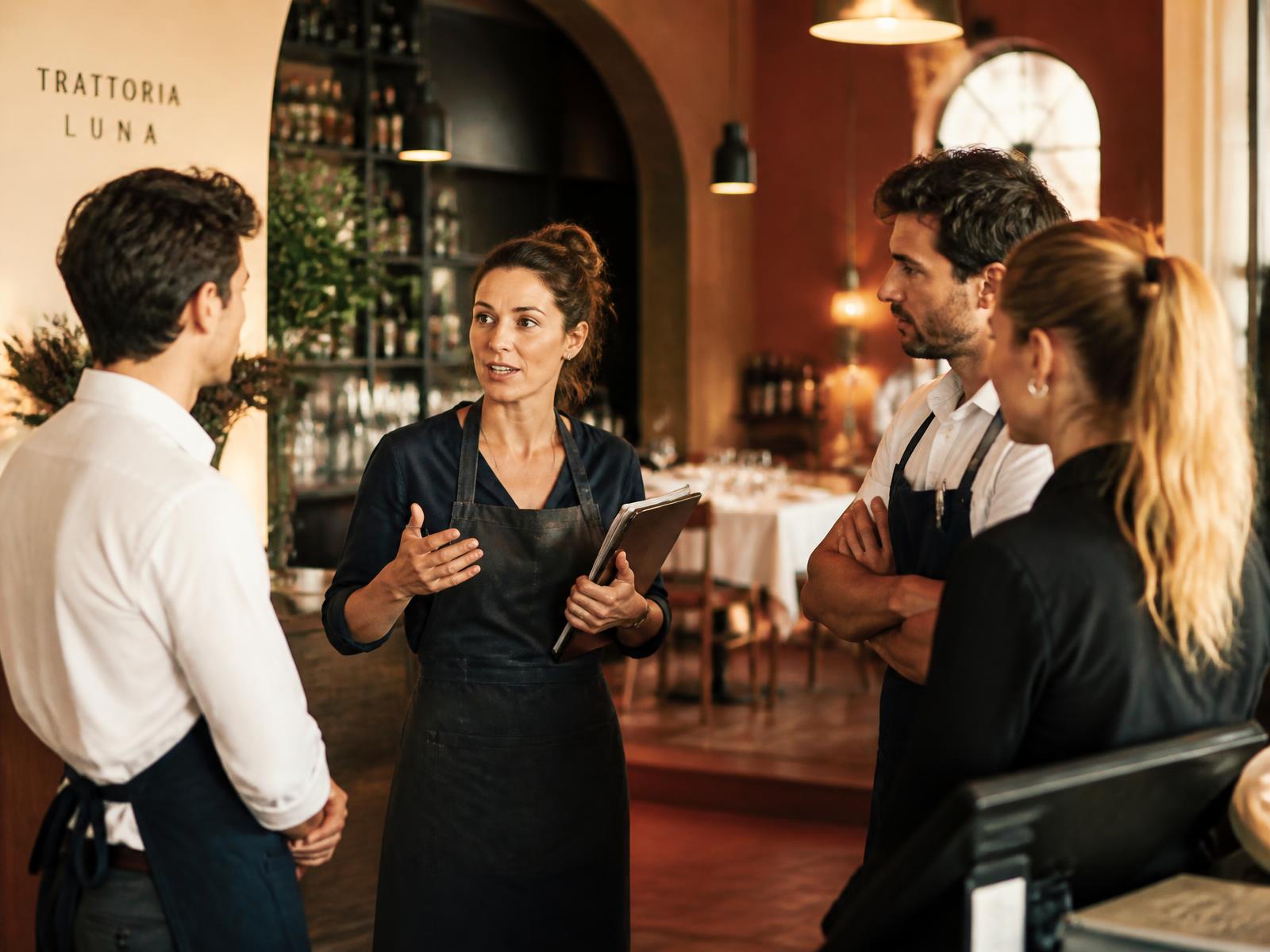 Titolare di ristorante che coordina lo staff di sala